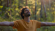 © Keitma - Portrait of a free happy Indian man with open arms enjoying life in meadows and nature background , young joyful asian male with good mental health