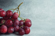 Close-Up of a Juicy Red Grapes Bunch on a Textured Grey Surface