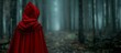 person in a red cloak in the dark forest. 