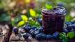 Homemade blueberry preserves or jam in a mason jar surrounded by fresh organic blueberry. Selective focus