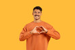 Man with moustache making heart shape with hands