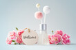 Fragrance diffuser with welcome tag and pink carnation flowers on vintage blue background