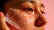 Close-up of a woman's face partially covered with a clear, hydrating facial mask against a soft pink background, conveying a sense of self-care and beauty. Banner. Copy space