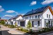 Residential area with white modern family eco houses with solar panels on the roofs. Renewable solar energy concept