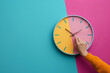 © Sunday Cat Studio - Hand adjusting clock, time management concept, pastel background.