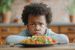 Cute African American child expresses dislike for healthy salad at home