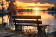 Wooden bench near river at sunset