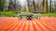 Mini 2 drone with cpl lens filter on orange landing mat platform. Quadcopter on nylon foldable launch pad close-up.