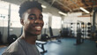 Young Athletic Black Man with a Friendly Smile in a Well-Equipped Gym, Copy Space