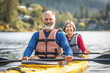 A retired couple enjoys a leisurely kayaking trip together, gliding down the river surrounded by the beauty of nature.