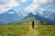 enthusiastic hiker with arms outstretched on Mannlichen mountain trail, swiss alps
