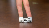 Fototapeta Dmuchawce - Hand turns dice and changes the word dream to reality.