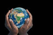 © polack - Afro person holds the Earth between their hands isolated on black background. Concept of responsibility and care for the planet, with copy space