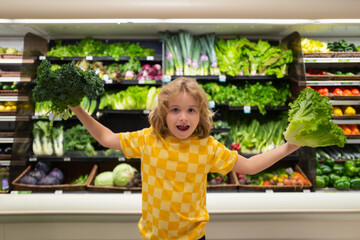 Wall Mural - Child with lettuce chard vegetables. Kid is choosing fresh vegetables and fruits in the store. Child buying food in grocery supermarket. Buying in grocery store. Groceries in the supermarket.