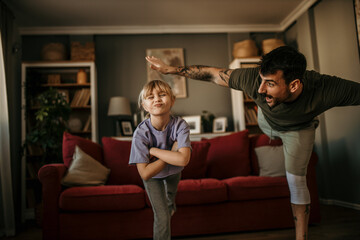 father and his daughter balancing together on one leg during a home workout