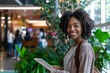 © Photo Luxe - A young African American businesswoman with curly hair smiles while using her tablet in a modern office setting, Generative AI