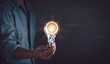 Businessman hand holding light bulb for ideas and innovation. concept for creative and inspiration, learning new things ,study of knowledge and analytical thinking problem solving