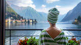 Fototapeta  - a woman with a green and white striped towel on her head stands in front of a mountain view
