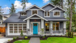 A large gray craftsman new construction house with a landscaped yard and leading pathway sidewalk ,painted craftsman house exterior with black shutters and white trim