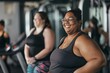 Two women are smiling and posing for a picture in a gym. One of them is wearing glasses