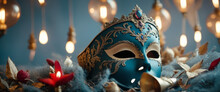 The Image Features A Blue Mask With A Crown On Top, Surrounded By Red Flowers And Lit Candles. The Background Is Blue With A Light, Garland-like Design.