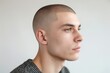 Profile view of a young man with a neat buzz cut against a light background