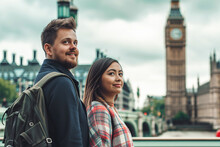 A Man And A Woman Are Standing Together In Front Of A Clock Tower, Likely Big Ben In London. The Couple Is Facing The Camera, With The Intricate Details Of The Clock Tower Visible Behind Them