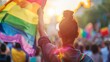 Individual raising a rainbow flag at a pride parade, backlit by the sun. Public demonstration and pride festival concept with copy space