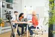 © ultramansk - Creative team collaborates on a project with a laptop and digital screen in a modern office, recorded by a camera. Young business analyst evaluates environmental performance on screen in eco-strategy.