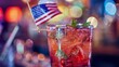 Close-up of cocktail with American flag and bokeh lights. Celebration and party concept