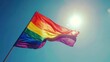 Hand holding a small rainbow flag at a pride parade. Selective focus outdoor photography with a blurred background. LGBTQ community and diversity concept