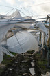 damage on the farm caused by wind , torn foil fro the tunnel structure
