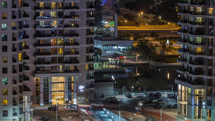 Wall Mural - Traffic at parking near entrance to skyscrapers in Jumeirah Lakes Towers night timelapse.