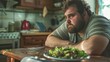 Unhappy fat man with a plate of green salad on table in kitchen is depressed during dieting. The concept of negative consequences of a strict diet. Generative ai