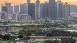 Fototapeta Miasto - Jumeirah lake towers skyscrapers and golf course day to night timelapse, Dubai, United Arab Emirates