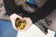 Close up shot of the hands of a girl holding a glass of whisky. She is dressed in black pantyhose