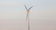 Green energy wind turbine against sky