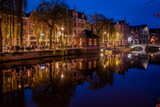 Fototapeta Miasto - Lier city in Belgium at night. warm lights reflect on water at evening people eat and drink in street of old houses historic building Buyldragershuisje. nightlife on Feix timmermansplein square