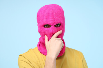 Wall Mural - Handsome young man in balaclava on blue background