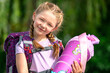 blondes glückliches sechsjähriges Mädchen mit Schultüte und Schulrucksack, erstklässlerin, sonniger tag, schulanfang