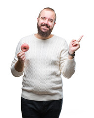 Wall Mural - Young caucasian hipster man eating sweet donut over isolated background very happy pointing with hand and finger to the side