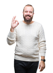 Wall Mural - Young caucasian hipster man wearing winter sweater over isolated background smiling positive doing ok sign with hand and fingers. Successful expression.