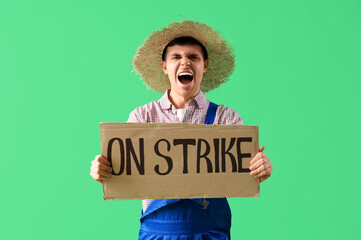 Wall Mural - Protesting male farmer holding placard with text ON STRIKE against green background