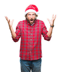 Wall Mural - Handsome hispanic man model wearing santa claus christmas over isolated background celebrating crazy and amazed for success with arms raised and open eyes screaming excited. Winner concept