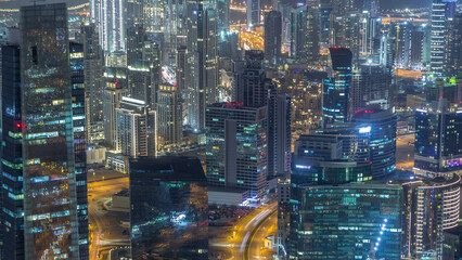 Wall Mural - Panoramic aerial view of business bay towers in Dubai night timelapse.