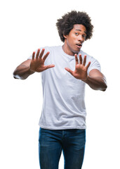 Canvas Print - Afro american man over isolated background afraid and terrified with fear expression stop gesture with hands, shouting in shock. Panic concept.