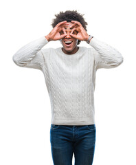 Poster - Afro american man over isolated background doing ok gesture like binoculars sticking tongue out, eyes looking through fingers. Crazy expression.