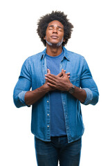 Sticker - Afro american man over isolated background smiling with hands on chest with closed eyes and grateful gesture on face. Health concept.