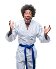 Canvas Print - Afro american man wearing karate kimono over isolated background celebrating crazy and amazed for success with arms raised and open eyes screaming excited. Winner concept