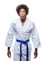 Canvas Print - Afro american man wearing karate kimono over isolated background making fish face with lips, crazy and comical gesture. Funny expression.